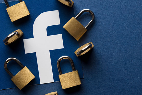 Facebook Logo, welches von geschlossenen Vorhängeschlössern umgeben ist.