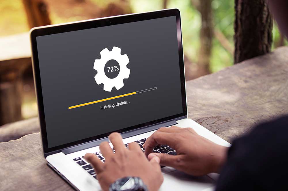 Mann installiert das aktuellste Systemupdate auf seinem Laptop.